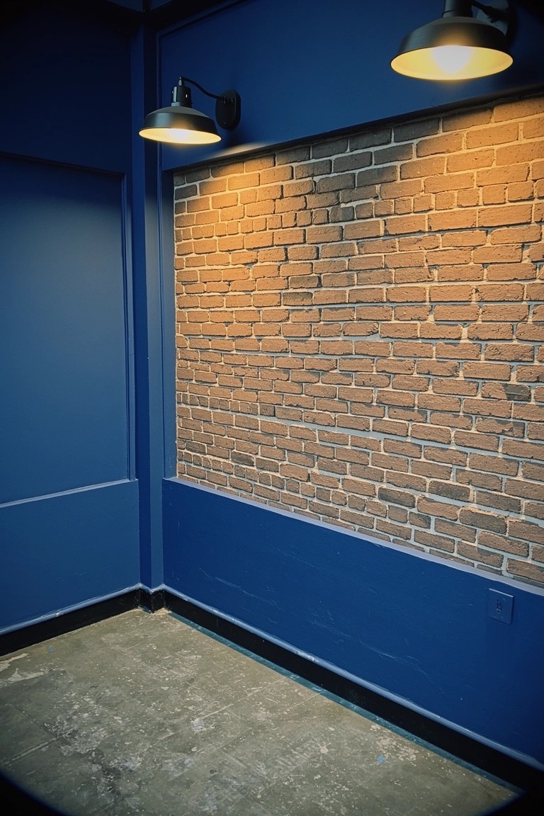 Deep navy blue painted walls framing warm brick in a cozy bedroom nook