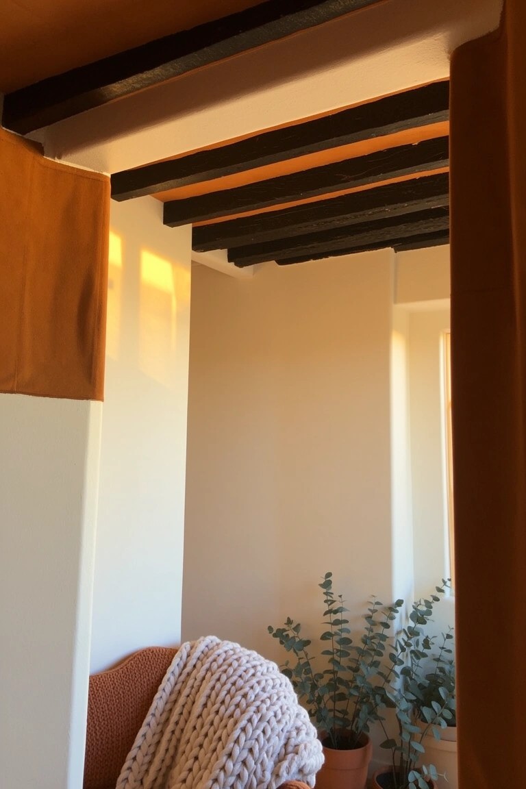 Bedroom nook with warm off-white walls under dark wooden beams, orange armchair draped in cream blanket, and potted eucalyptus plant