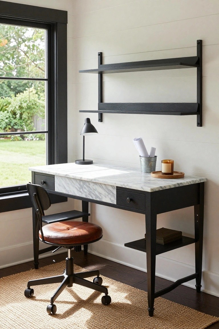 A home office featuring a black wood desk with white marble top, brown leather swivel chair, black wall shelves, desk lamp, and a large window overlooking a green garden and yard.