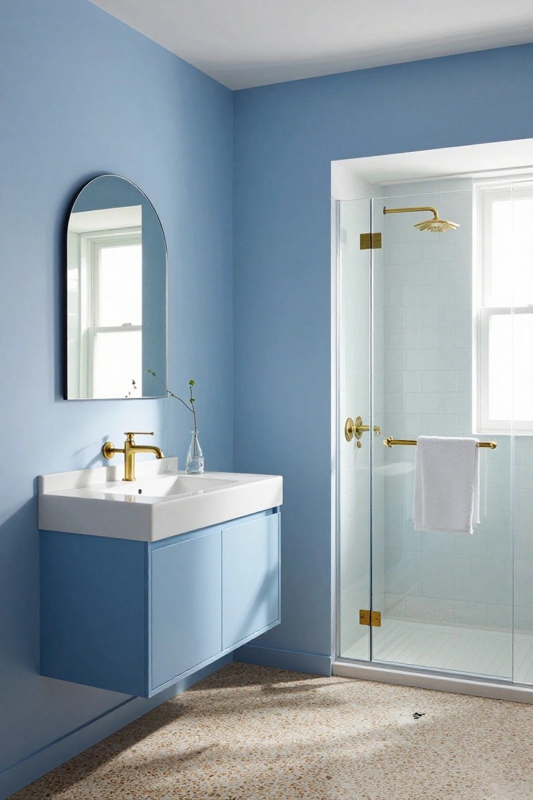 Bathroom featuring soft blue walls with a floating white vanity and glass shower enclosure